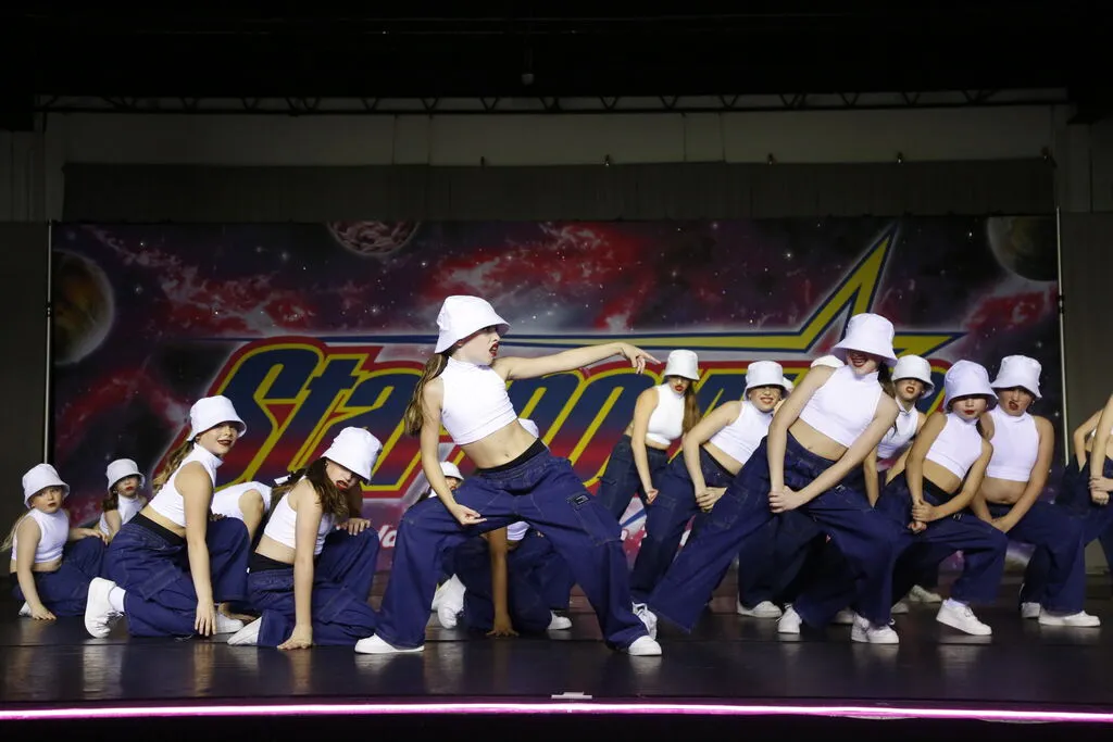 KICK's Hip Hop Crew performing on stage in matching white hats