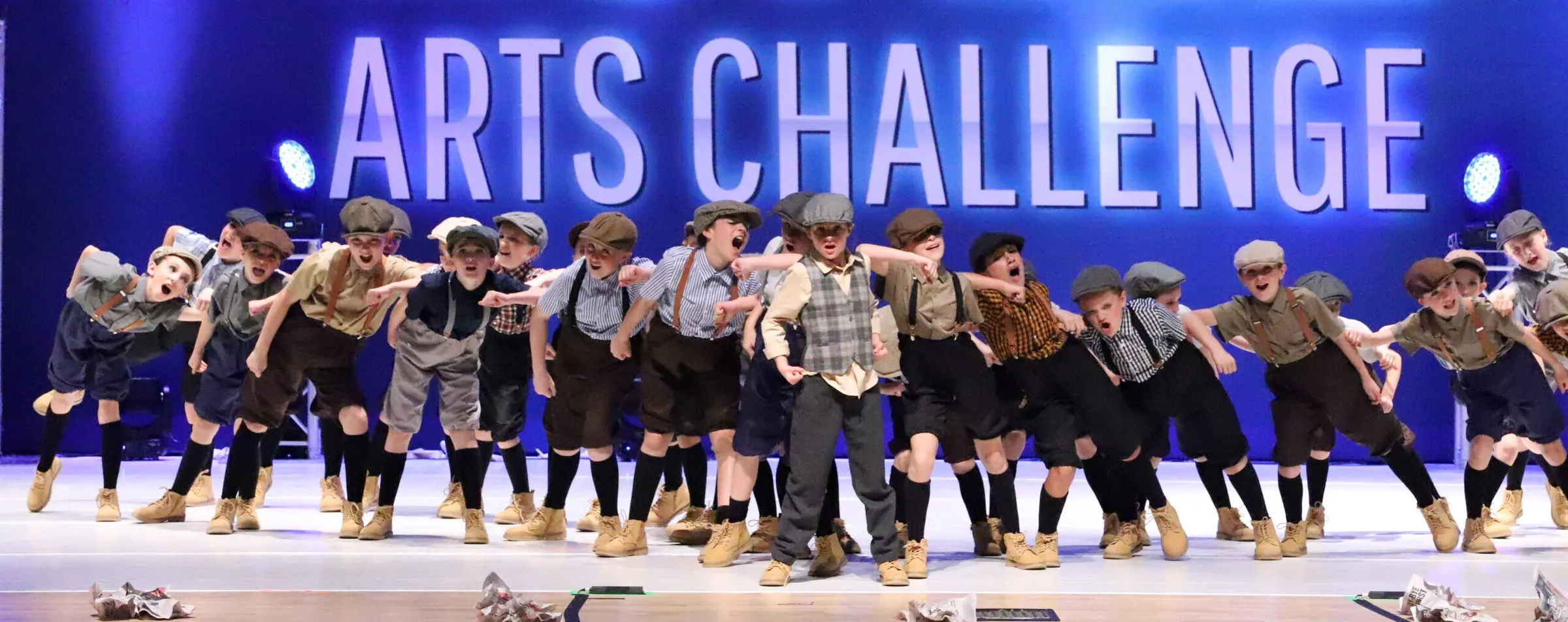 KICK's musical theater 'Newsies' number on stage in newsboy caps